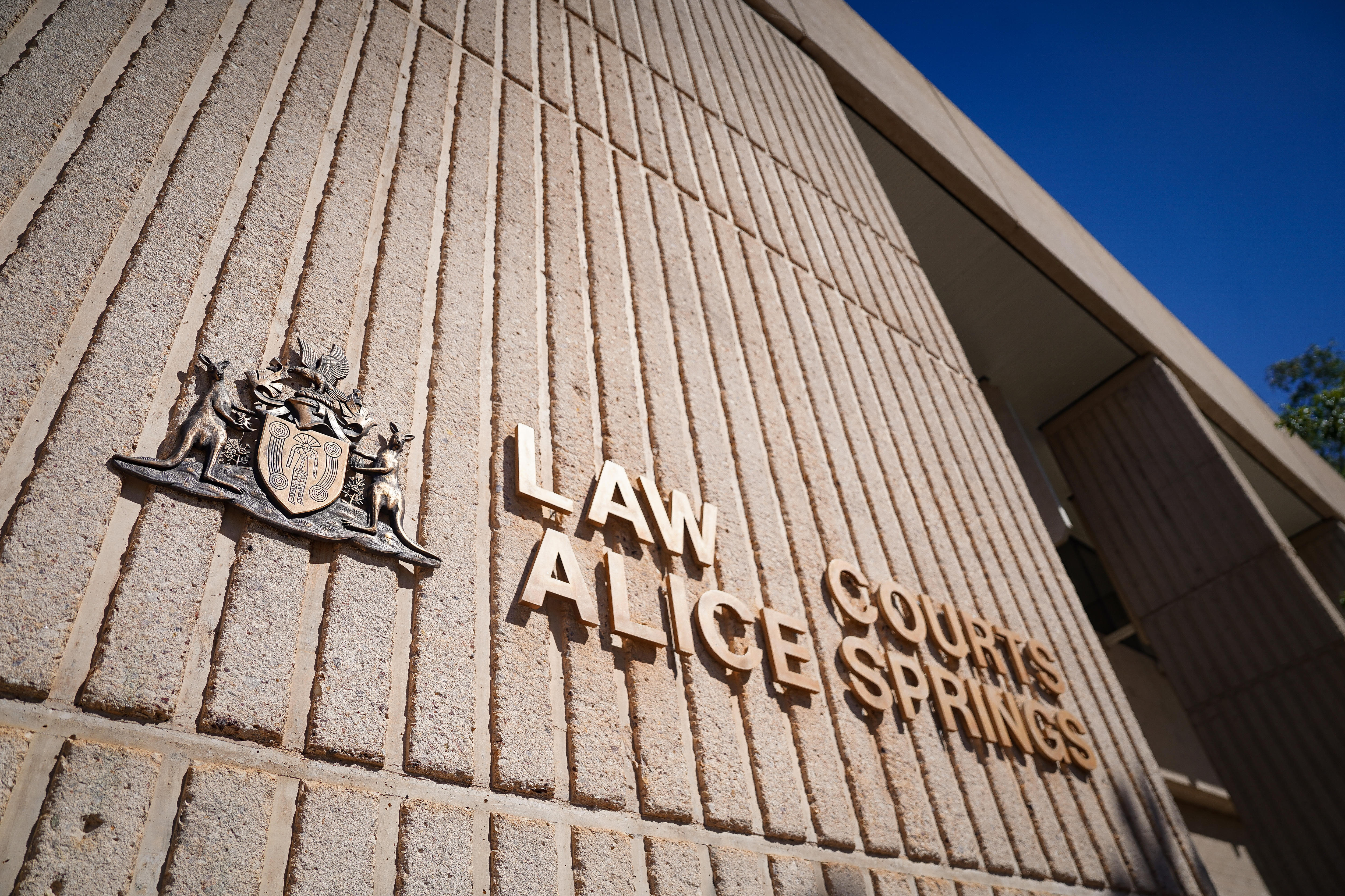 Gold lettering on the side of a building spells out: Law Courts Alice Springs