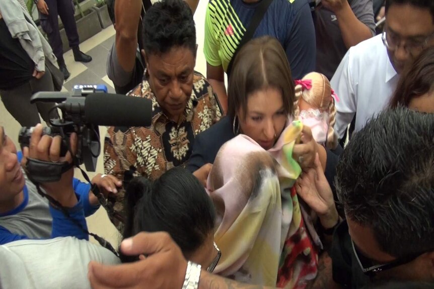 Australian Oshar Putu Melodi carries the daughter of convicted murderer Heather Mack from prison in Bali.