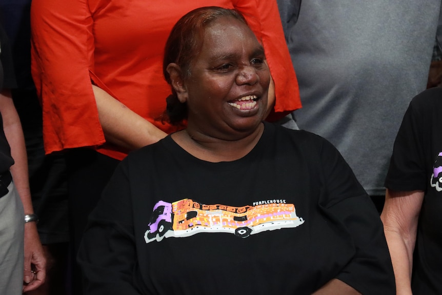 An Aboriginal woman in a black t-shirt smiles. 