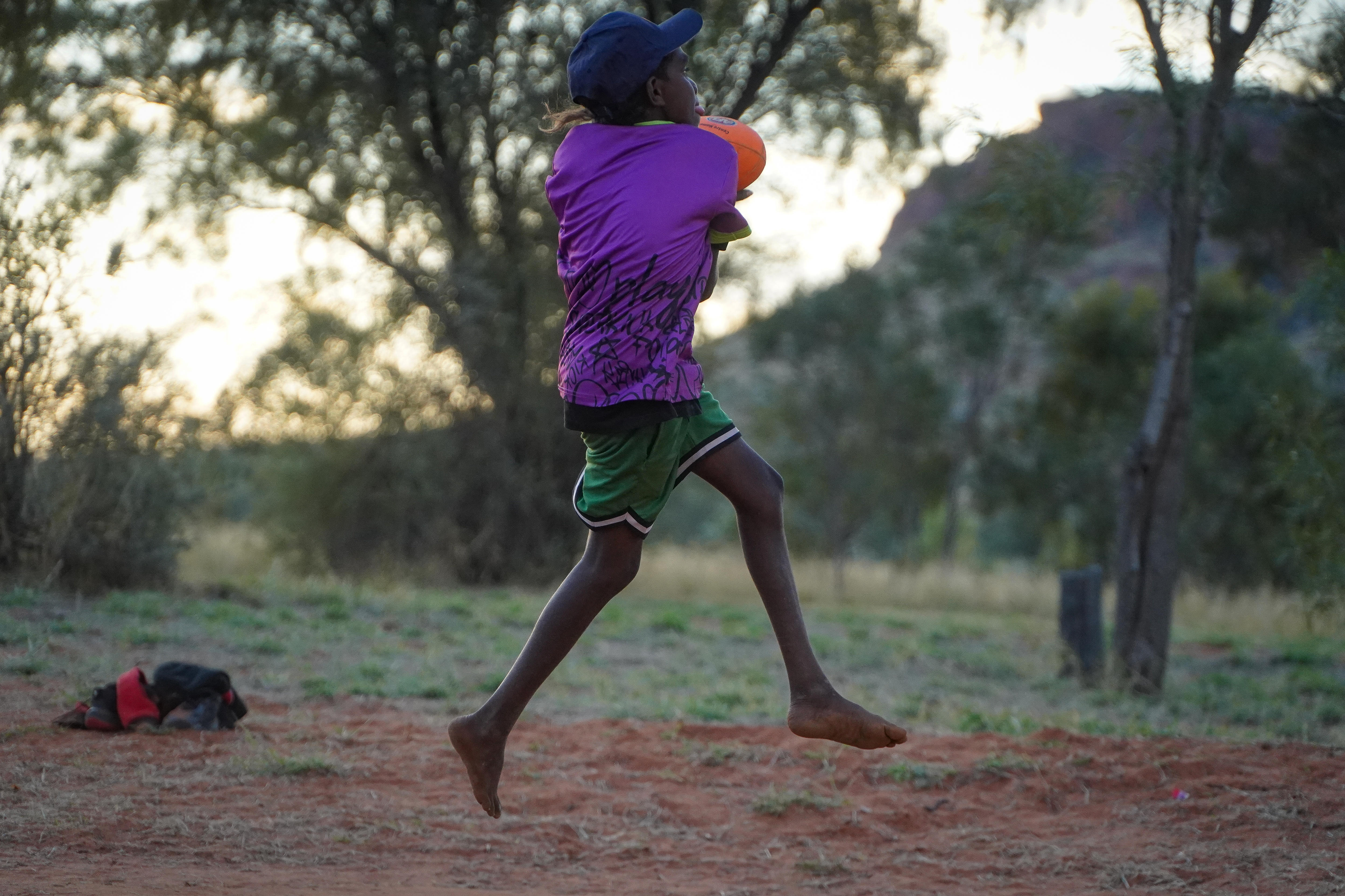 A child takes a mark during a game of Aussie Rules football.