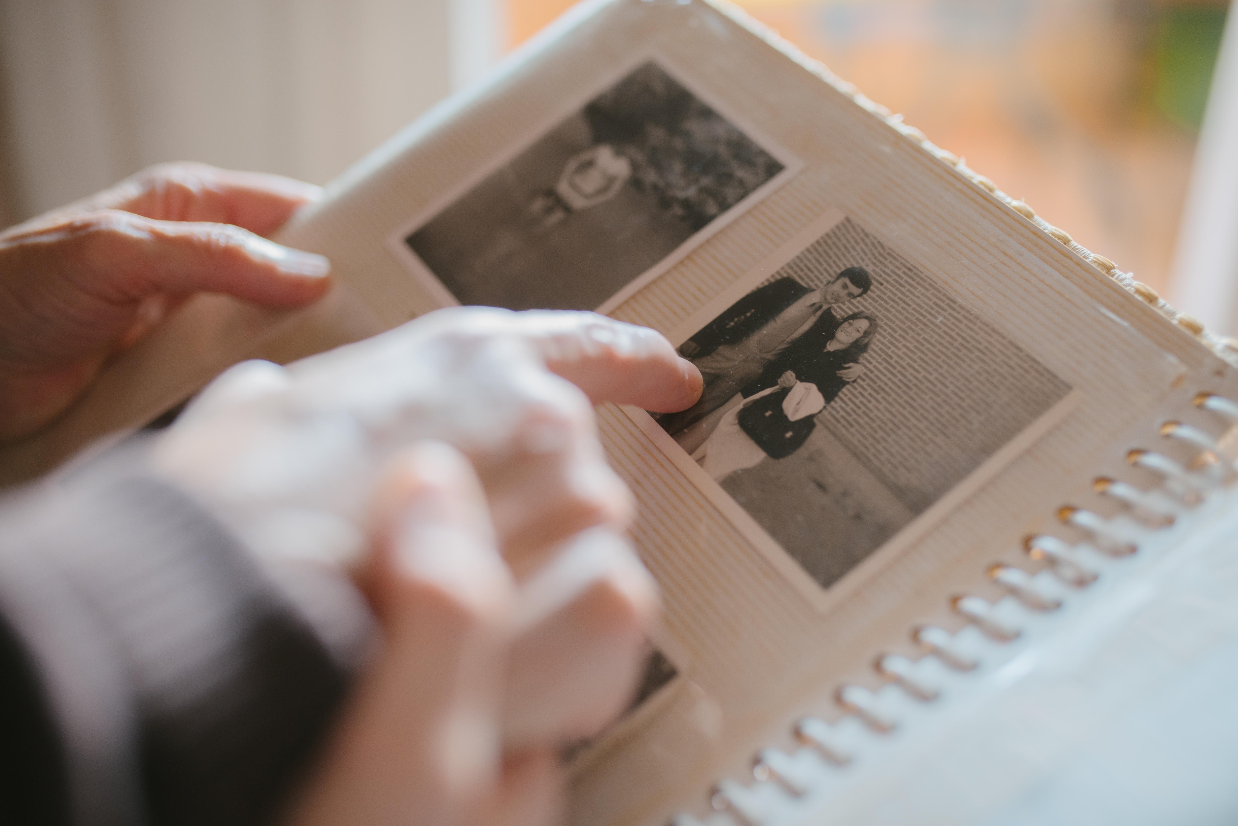 Grandmother sharing memories and stories with her granddaughter while showing her an old family photo album. 