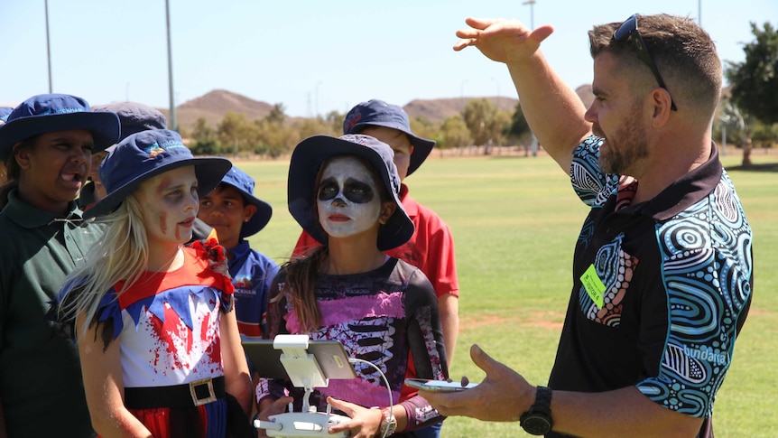 a man and a bunch of kids and a drone