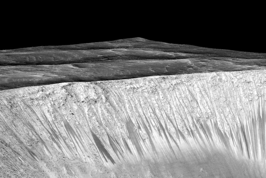 Dark narrow streaks coming out of the walls of Garni crater on Mars a few hundred metres in length