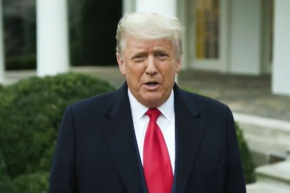 Donald Trump wearing a red tie and a dark suit.