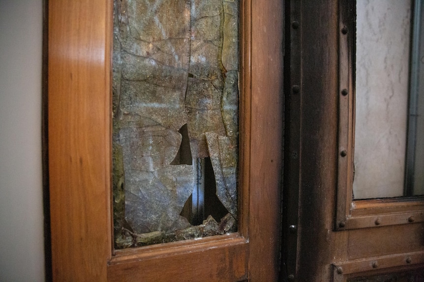 Interior wooden doors show smashed glass