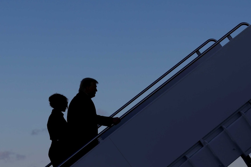 President Donald Trump departs next to first lady Melania Trump from the Joint Base Andrews, Maryland, U.S., January 20, 2021.