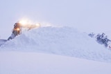 A snow plough moving a large drift.
