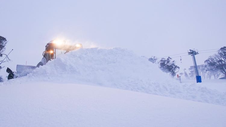 A snow plough moving a large drift.