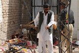 Pakistani security officials examine the site of the bomb explosion.