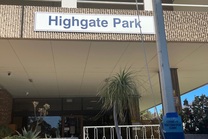 A sign on a concrete building saying Highgate Park
