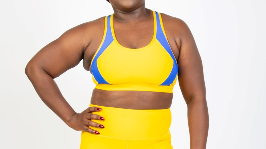 A woman wearing a bright yellow sports bra, in a story about how to choose the best fitting sports bra.
