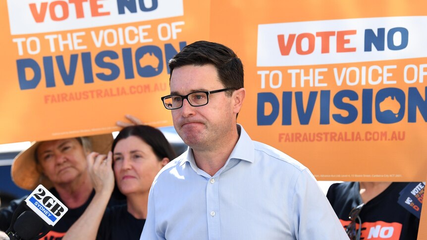 David Littleproud speaks at a voting centre in Brisbane in front of signs that say NO. 