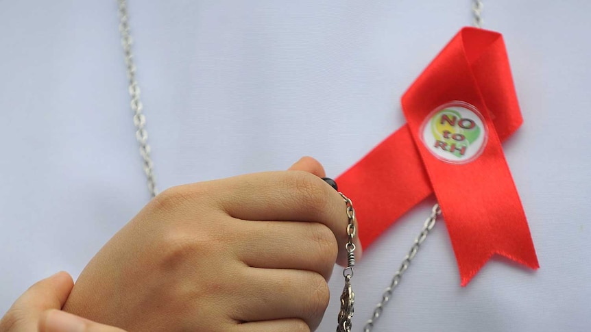 A Catholic nun wearing an anti-Reproductive Health ribbon