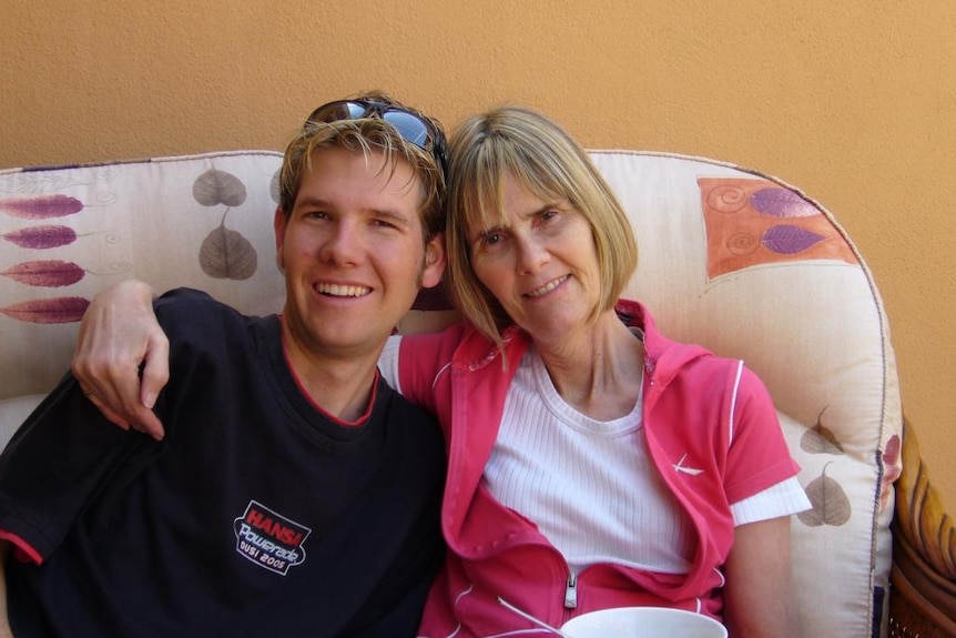 Neil and his mother Mary Powell relax on a sofa. Mary has her arm around Neil's shoulder
