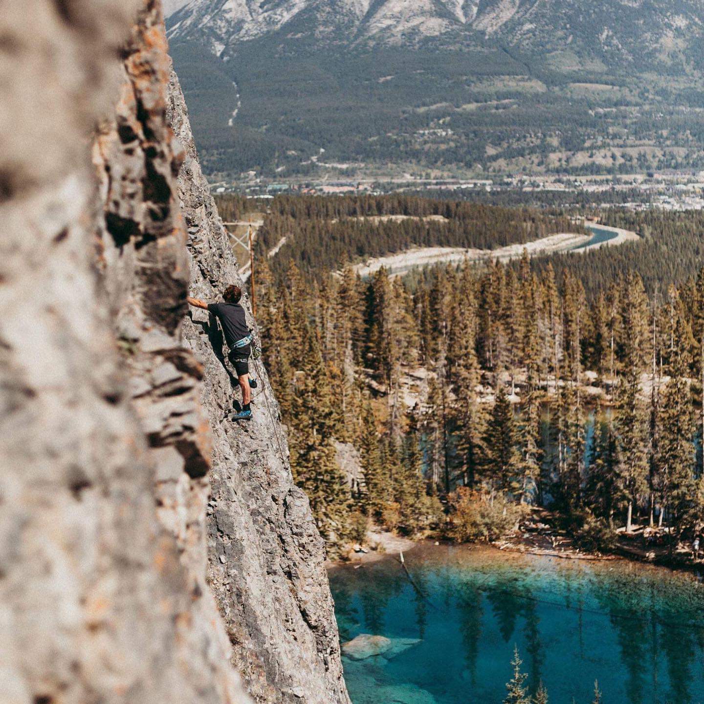 Scott Murphy climbs a rockface above a lake