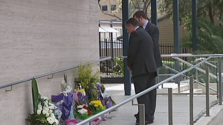 Police Association members lay flowers where a police employee was shot