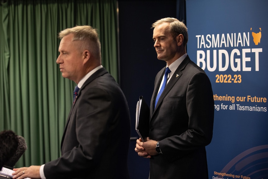 Jeremy Rockliff speaks at a lectern while Michael Ferguson stands beside him.