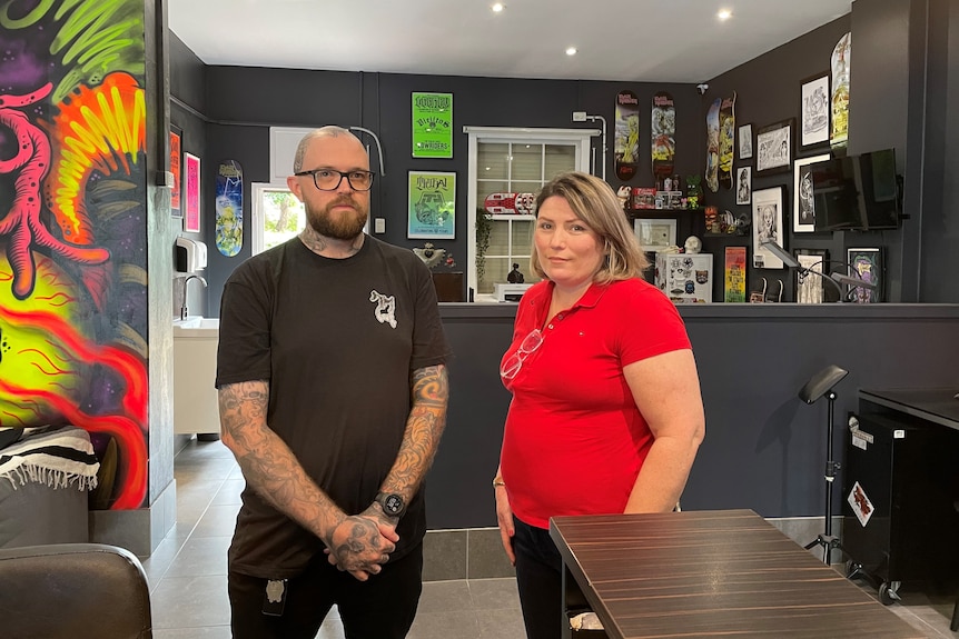 James Thompson and Samantha Morrison stand in the tattoo parlour. 