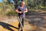 Woman holding python in bushland