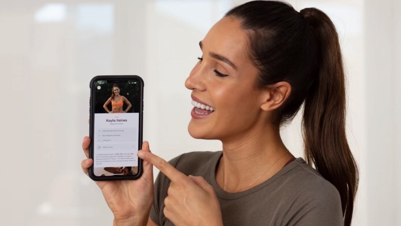 A woman looks at a smartphone.