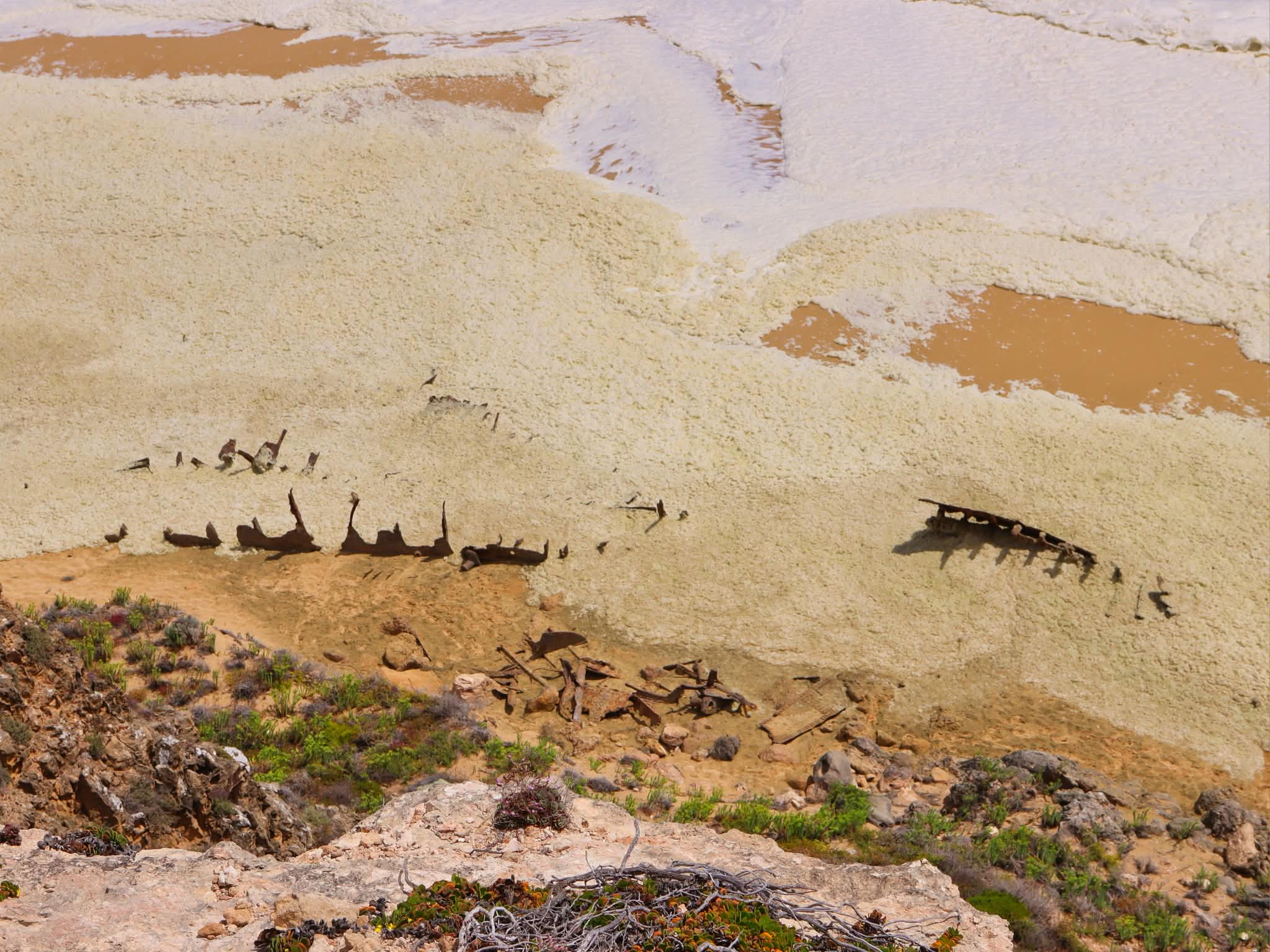 Una vista aérea del agua marrón espumosa que se lava en una playa