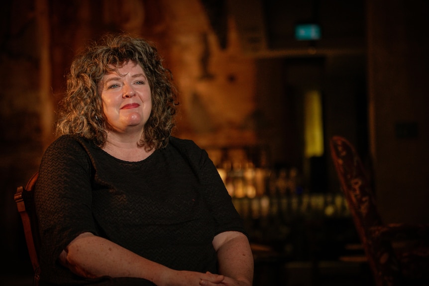 A woman sitting on the chair and smiling.