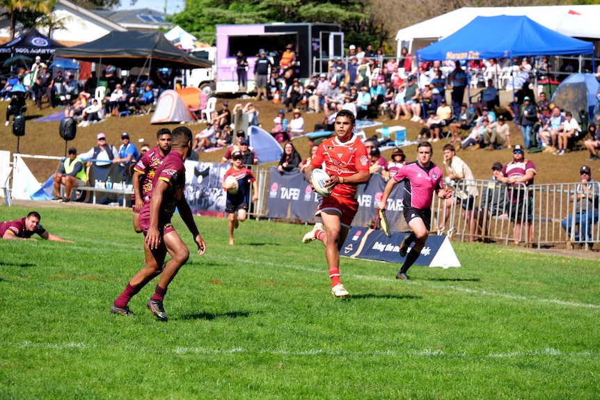 Rugby league star Latrell Mitchell runs across the rugby league field 