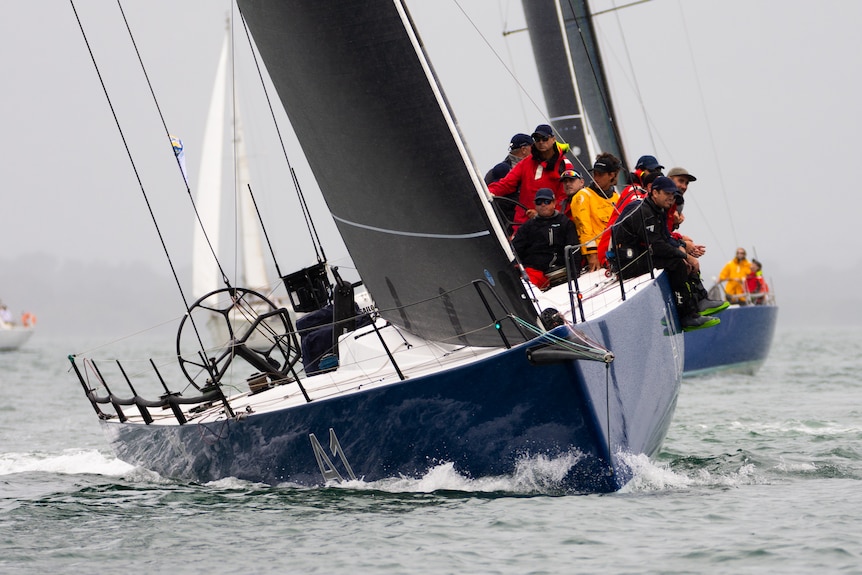 a yacht racing through the water with the crew on board