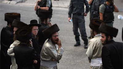 Israeli police stand guard as ultra-Orthodox Jews protest in Jerusalem against the opening of a car park during the Sabbath.