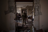 A Ukraine unit commander poses for photo in a mirror inside the regional administration building.