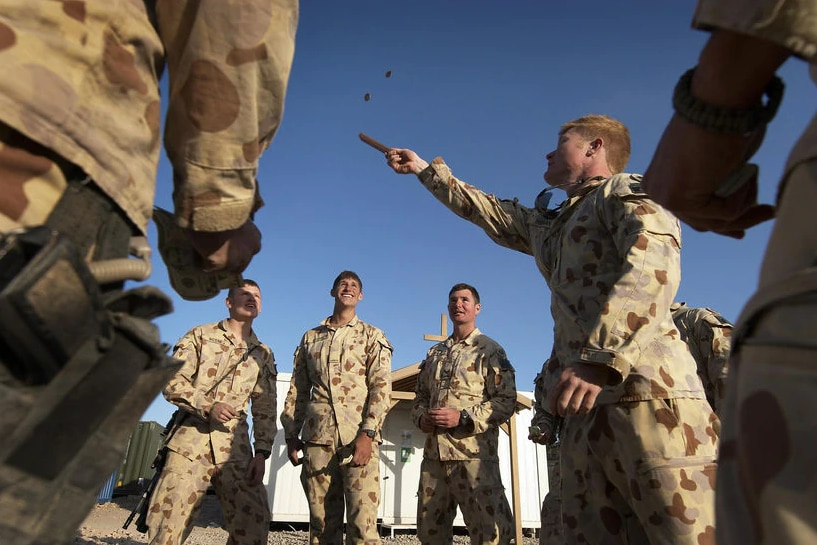 A group of soldiers in Afghanistan playing a game of two-up.