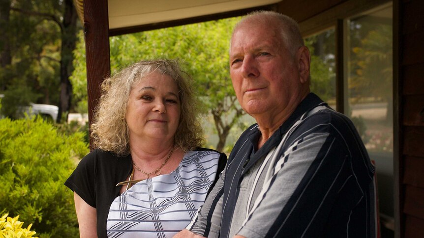 Brian and Karen Mitchell stand together on a balcony.