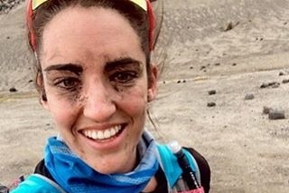 A marathon runner has dirt all over her face after a day of competition.
