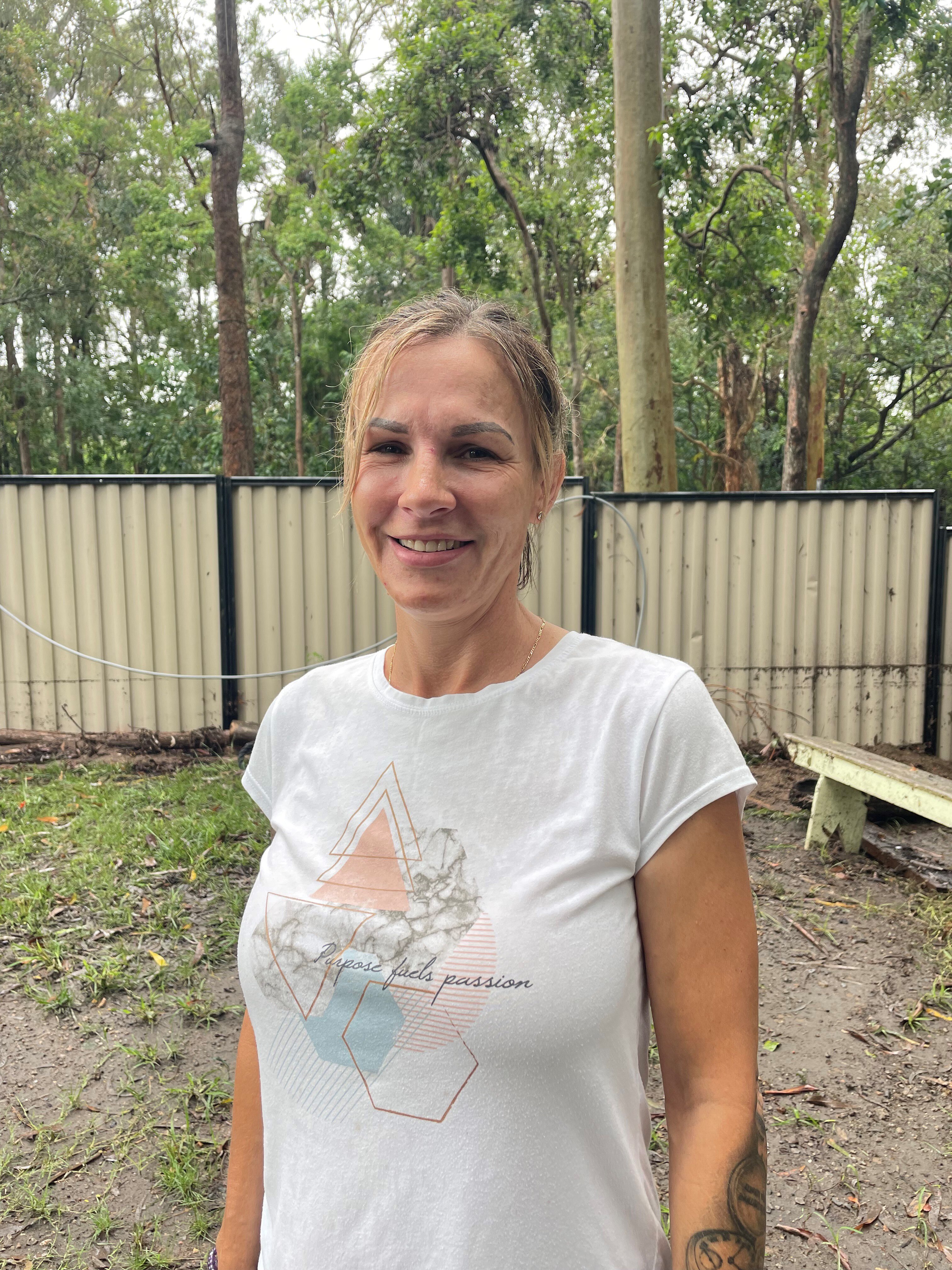 woman standing in a flooded backyard