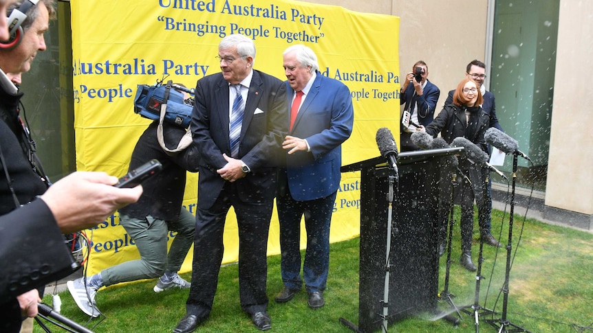 A garden sprinkler interrupted Clive Palmer and Brian Burston's media conference (Photo: AAP)