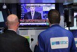 Traders on the floor of the New York Stock Exchange watch the announcement of Trump's tax plan on television.