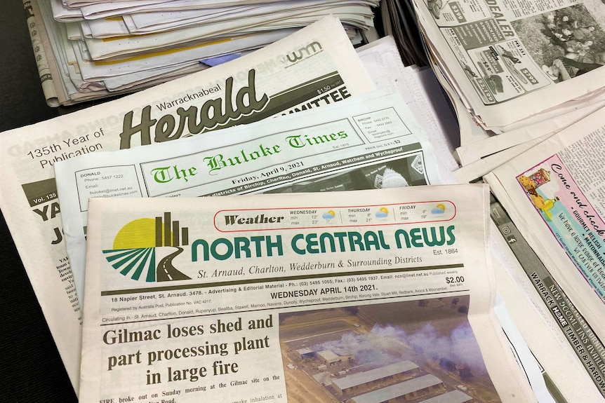 A stack of newspapers with the names 'Warracknabeal Herald', 'Buloke Times' and 'North Central News' sit in a pile