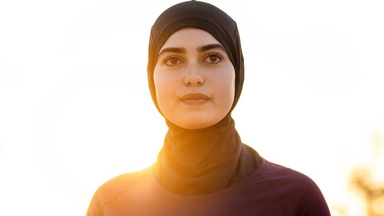 A woman wears a running hijab.