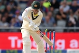 David Warner attempts a shot but the ball hits the stumps, sending the bails flying