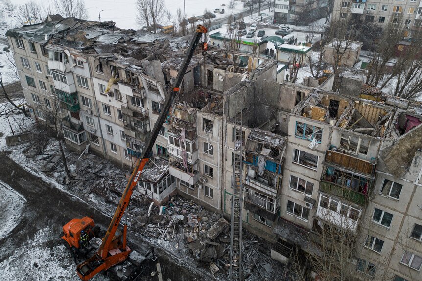 Rescue workers clear the rubble of the residential building which was destroyed by a rocket.