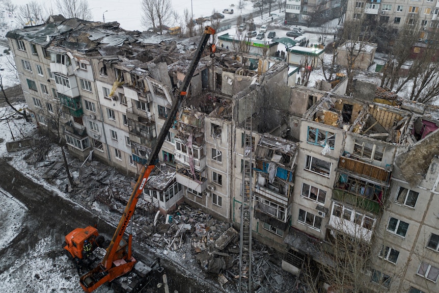 Rescue workers clear the rubble of the residential building which was destroyed by a rocket.