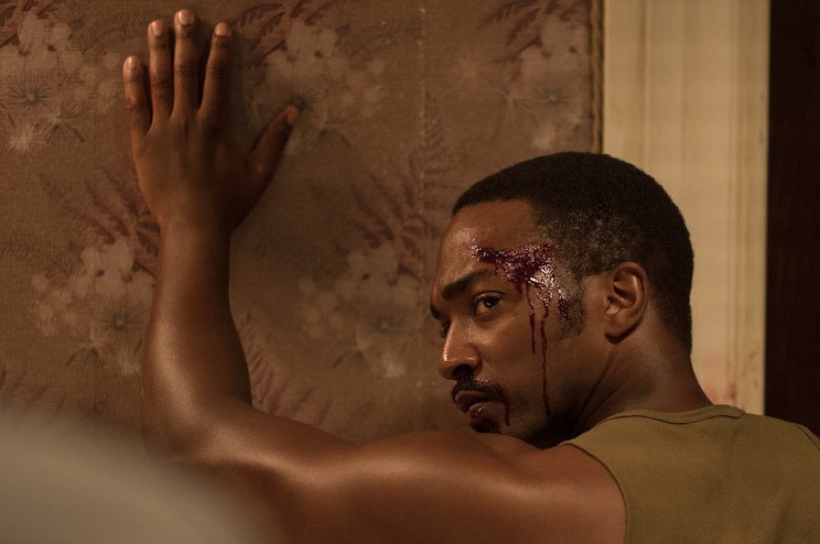 Still image from 2017 film Detroit of actor Anthony Mackie with his hands against the wall and head bloodied.