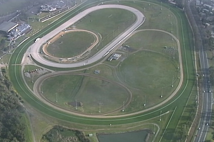 An aerial shot of a green horse racing track.