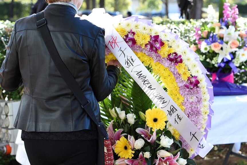 A mourner places a floral wreath outside the Hillsong Church in Baulkham Hills.