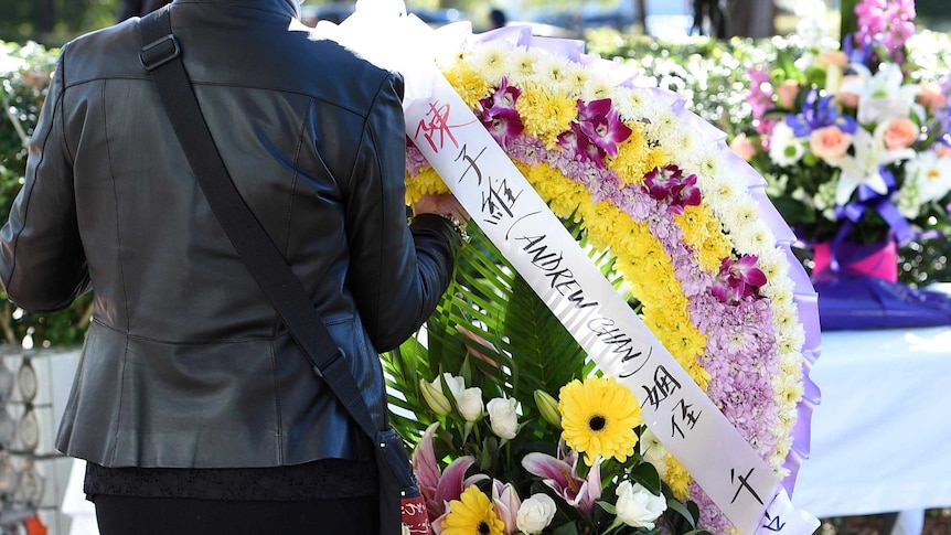 A mourner places a floral wreath outside the Hillsong Church in Baulkham Hills.