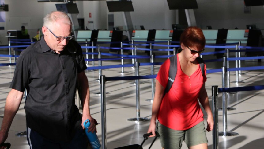 Brendan and Anna Murphy drag luggage through Perth Airport.