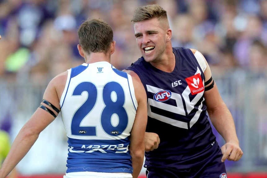 Two football players tussle during a game