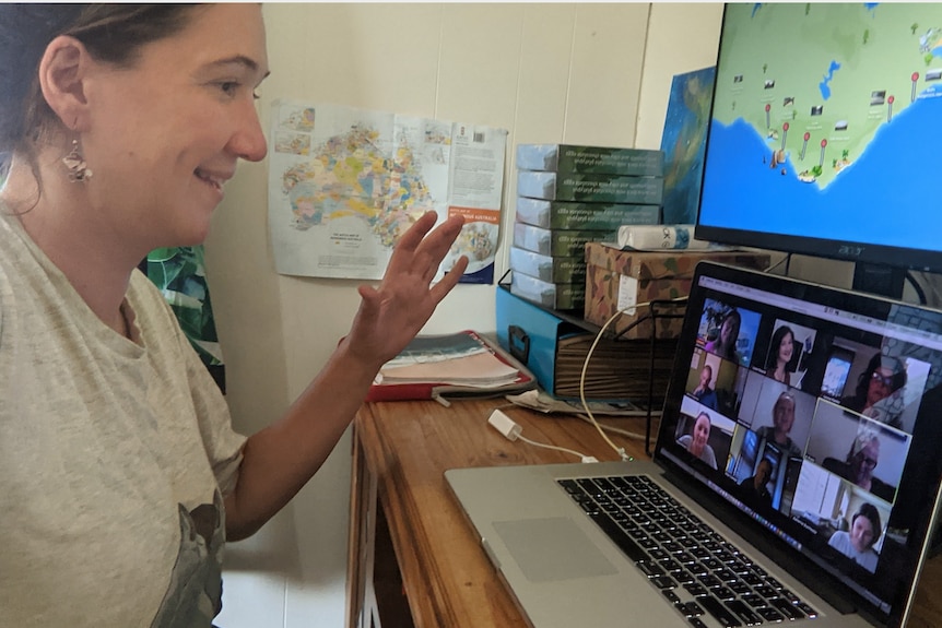 A woman talks to a group of zoom tourists