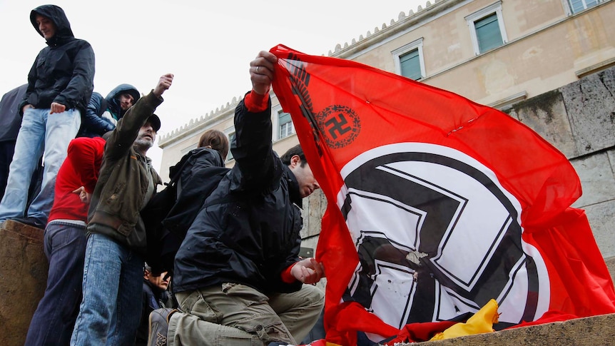 Greek anti-austerity protesters prepare to burn German and Nazi flags