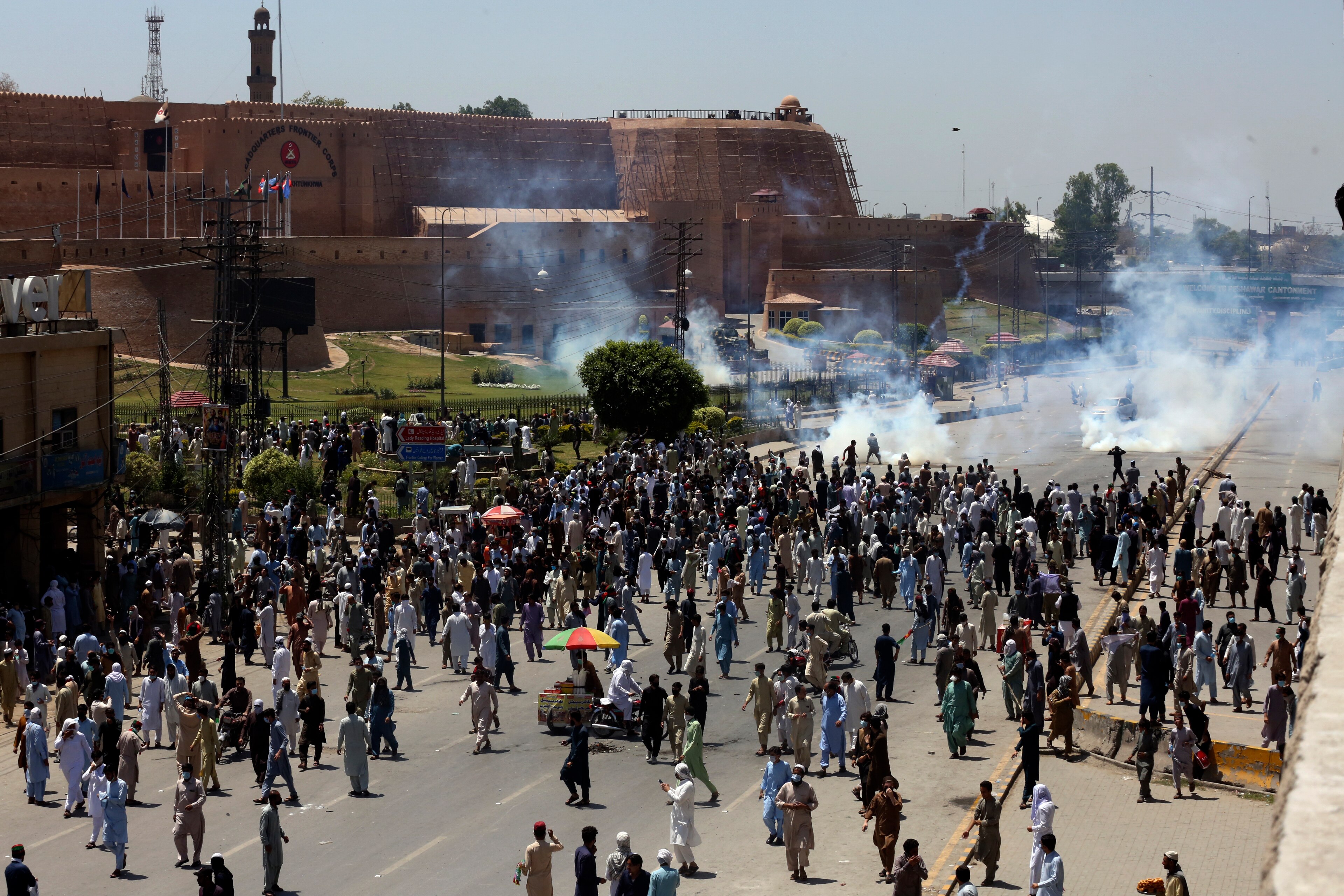 Picture of a large crowd on a road in front of an old building 